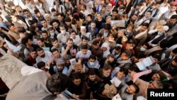 Sekumpulan warga Afghanistan tampak berkumpul di luar kantor imigrasi pada 6 Oktober 2021 setelah Taliban mengumumkan bahwa mereka akan mulai menerbitkan paspor kembali kepada para warga. (Foto: Reuters/Jorge Silva)