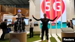 An SK telecom exhibitor directs the robot's movements using 5G on the last day at the Mobile World Congress in Barcelona.