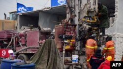 Anggota tim SAR berupaya melakukan pencarian korban di lokasi ledakan tambang emas di Qixia, provinsi Shandong, China timur. Sedikitnya 22 penambang terjebak di bawah tanah di tambang emas ini. (Foto: STR/berbagai sumber / AFP)/China)
