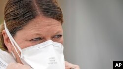 Seorang perawat bernama Yvette Laugere menyesuaikan masker N95-nya saat berada di lokasi pengujian COVID-19 gratis di Houston. (Foto: AP)