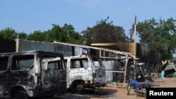 FILE - Burnt vehicles and houses are pictured on a street, after Boko Haram militants raided the town of Benisheik, west of Borno State capital Maiduguri.
