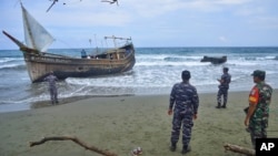 Indonesian military personnel inspect a boat used to carry Rohingya refugees after it landed in Aceh province, Indonesia, Sunday, Dec. 25, 2022. (AP Photo/Rahmat Mirza)