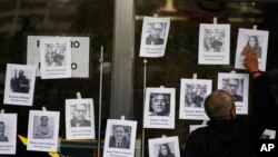 Seorang pria memasang foto pewarta yang terbunuh di luar kantor Kejaksaan Agung Meksiko di Mexico City, 24 Agustus 2022. (Foto: AP)