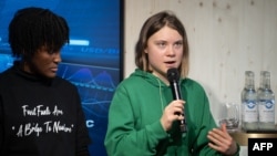 Swedish climate activist Greta Thunberg, right, speaks next to Ugandan colleague Vanessa Nakate during a session with International Energy Agency chief Fatih Birol, on the sidelines of the World Economic Forum in Davos, Switzerland, Jan. 19, 2023.