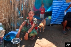 FILE - Displaced people from Myanmar live under a makeshift tent along the Thai side of the Moei River in Mae Sot, Thailand, Feb. 7, 2022.