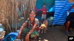 FILE - Displaced people from Myanmar live under a makeshift tent along the Thai side of the Moei River in Mae Sot, Thailand, Feb. 7, 2022. 