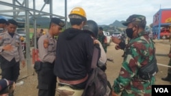 Personel TNI-POLRI melakukan pemeriksaan terhadap pekerja yang hendak memasuki pabrik smelter PT GNI di Morowali Utara, Sulawesi Tengah, 19 Januari 2023 (Foto : VOA/Yoanes Litha)