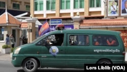 កញ្ញា ឈឹម ស៊ីថរ អង្គុយ​ក្រោយគេ​នៅក្នុង​រថយន្ត និង​បាន​លើកដៃ​ជា​សញ្ញា ខណៈ​រថយន្ត​​នេះ ដឹក​កញ្ញា​យក​ទៅ​ឃុំខ្លួន​នៅ​ពន្ធនាគារ​ព្រៃស នៅ​ថ្ងៃ១៩ ខែមករា ឆ្នាំ២០២៣។ (លាស់ លីបលីប/វីអូអេ)