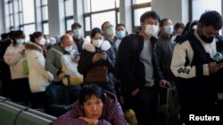 중국 베이징에서 춘제를 맞아 고향으로 가려는 사람들이 마스크를 쓰고 기차 탑승을 기다리고 있다. (자료사진) 