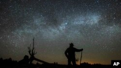 In this file photo, Dave Cooke observes the Milky Way over a frozen fish sanctuary in central Ontario, north of Highway 36 in Kawartha Lakes, Ontario, Canada, early Sunday, March 21, 2021. (Fred Thornhill/The Canadian Press via AP)