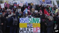 Perawat memegang spanduk saat melakukan pemogokan di luar Royal College of Nursing, di London, Rabu, 18 Januari 2023. (Foto: AP)