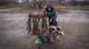 Serhi Zamulenko sells fish on the side of the road, despite shells frequently falling in the area, in Chasiv Yar, Ukraine, Jan. 22, 2023. (Yan Boechat/VOA)