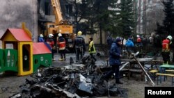 Petugas tanggap darurat tampak bekerja di lokasi jatuhnya helikopter di Brovary, di luar Kota Kyiv, Ukraina, pada 18 Januari 2023. (Foto: Reuters/Valentyn Ogirenko)