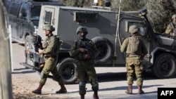 Members of Israeli security forces close off the area of a reported stabbing attack northwest of Ramallah in the West Bank, on Jan. 21, 2023. 