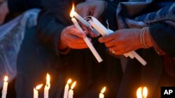 Women light candles during a prayer ceremony for victims of a suicide bombing inside a mosque, in Peshawar, Pakistan, Feb. 1, 2023.