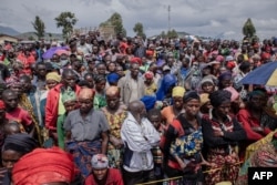 FILE - Displaced people wait for a distribution of food and non-food items, in Munigi camp, in the Democratic Republic of Congo's North Kivu province, Dec. 5, 2022.