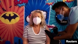 FILE - A woman receives the Moderna coronavirus disease booster vaccine targeting BA.4 and BA.5 Omicron subvariants at Skippack Pharmacy in Schwenksville, Pennsylvania, Sept. 8, 2022. 