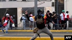 Demonstrators swing makeshift slingshots during clashes with riot police within a protest against the government of Dina Boluarte asking for her resignation and the closure of Congress, in Lima on Jan. 24, 2023.