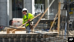FILE - People work at a construction site in Miami, Jan. 24, 2023.