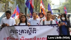 លោក រ៉ុង ឈុន មេដឹកនាំ​សហជីព​ដៃ​កាន់​ទង់ជាតិ​កំពុង​ដឹកនាំ​ធម្មយាត្រា​ថ្មើរជើង​ស្តីពី​«​សីល​ធម៌​សង្គម»​ចេញ​ពី​​រាជធានី​ភ្នំពេញ​​ នៅ​ថ្ងៃទី១ ខែកុម្ភៈ ឆ្នាំ២០២៣។ (លាស់ លីបលីប/វីអូអេ) 