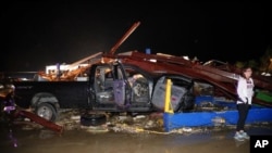 Seorang warga Canton, Texas, memeriksa kerusaksan di dealer mobil Dodge pasca hantaman tornado di kotanya, 29 April 2017.