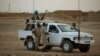 FILE - In this July 28, 2013 photo, United Nations peacekeepers stand guard at a polling station, during presidential elections in Kidal, Mali.