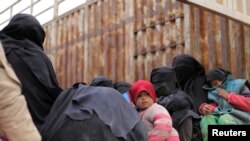 Children sit on the back of a truck near the village of Baghuz, Deir el-Zour province, in Syria, March 7, 2019.