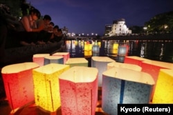 Orang-orang melepaskan lentera kertas di Sungai Motoyasu untuk mengenang para korban bom atom pada peringatan 77 tahun pengeboman, di Hiroshima, Jepang, 6 Agustus 2022. (Foto: Kyodo via Reuters)