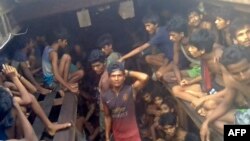 Tangkapan layar dari video AFPTV yang diambil pada 4 Desember 2020 tampak para penyelundup manusia Myanmar (tengah) bersama migran Rohingya di dalam sebuah kapal di Chakmarkul, 26 Agustus 2020.