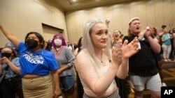 Allie Ugley, middle, an Allen County resident, holds back tears after hearing the news that the "No" votes won on a proposed amendment to the Kansas Constitution for Constitutional Freedom election watch party in Overland Park, Kansas, Aug. 2, 2022. 
