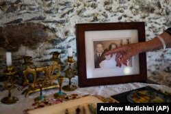 Rabi Barbara Aiello menunjuk dirinya yang lebih muda dalam foto keluarga lama, di sinagoga "Ner Tamid del Sud" (The Eternal Light of the South) di Serrastretta, Italia selatan, Jumat, 8 Juli 2022. (Foto: AP/Andrew Medichini)