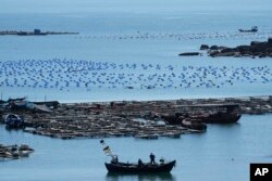 Sebuah perahu bergerak melintasi air di titik terdekat daratan China ke Taiwan, di Pingtan di Provinsi Fujian, Cina tenggara, Jumat, 5 Agustus 2022. (Foto: AP)