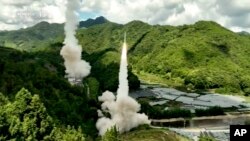 中国电视节目截屏，画面字幕：东部战区火箭军不对对台岛东部外海预定海域实施常导火力突击 全部精准命中目标。-美联社提供照片