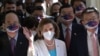 U.S. House Speaker Nancy Pelosi, center, waves to journalists during her arrival at Parliament in Taipei on August 3, 2022.