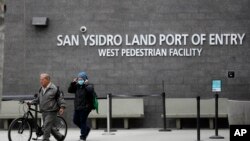 20일 멕시코 티후아나에서 미국 샌디에이고로 입국한 여성이 마스크를 고쳐쓰고 있다.