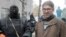 In this photo taken on April 13, 2014, American reporter Simon Ostrovsky, right, stands with a pro-Russian gunman near a police station in the eastern Ukrainian town of Slovyansk. 