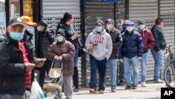 រូបឯកសារ៖ មនុស្ស​ម្នា​ពាក់ម៉ាស់​ដើម្បី​បង្ការ​ជំងឺ​កូវីដ១៩ ខណៈ​ឈរ​រង់ចាំ​ចូល​ទិញ​ម្ហូបអាហារ​នៅ​ក្នុង​ផ្សារ​មួយ នៅ​សង្កាត់ Queens ទីក្រុង​ញូវយ៉ក សហរដ្ឋអាមេរិក ថ្ងៃទី១៤ ខែមេសា ឆ្នាំ២០២០។ 