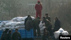 지난 2008년 12월 북한 신의주 주민들이 미국에서 지원 받은 식량을 트럭에서 내리고 있다. 자루에 'USAID(미국제개발처)' '미국에서 보내온 선물' 이란 문구가 씌여있다.