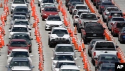 Lines of cars wait at a coronavirus testing site outside of Hard Rock Stadium, in Miami Gardens, Fla., June 26, 2020.