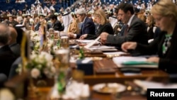U.S. Secretary of State John Kerry (C) attends the opening session of the Syrian Donors Conference at Bayan Palace Liberation Hall at the Bayan Palace in Kuwait City, Jan. 15, 2014.