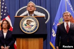 메릭 갈랜드(가운데) 미 법무부 장관이 24일 법무부 청사에서 중국인 기소 사건을 설명하고 있다. 오른쪽은 크리스토퍼 레이 연방수사국(FBI) 국장, 왼쪽은 리사 모나코 법무부 부장관.