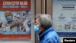 资料照：北京街头张贴鼓励老年人接种新冠疫苗的宣传画。（2022年3月30日）