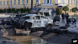 Damaged cars are seen at the scene of Russian shelling, in Kyiv, Ukraine, Oct. 10, 2022. Explosions on Monday rocked multiple cities across Ukraine, including missile strikes on the capital Kyiv for the first time in months.