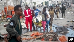Rescuers remove a body from the scene of a double car bomb attack in Mogadishu, Somalia, Oct. 29, 2022.