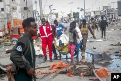 FILE - Rescuers remove a body from the scene of a double car bomb attack in Mogadishu, Somalia, Oct. 29, 2022.