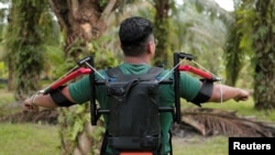 Mahasiswa peneliti Muhammad Haziq Ramli menunjukkan Terer, kerangka luar robot dalam uji coba prototipe di perkebunan kelapa sawit di Yong Peng, Johor, Malaysia, 8 September 2022. (REUTERS/Hasnoor Hussain)