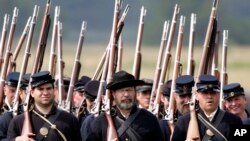 FILE — Re-enactors portraying the Union army's 20th Main, march during the 23rd Annual Gettysburg Civil War Heritage Days, in Gettysburg, Pa., June 25, 2005. Some historical battle re-enactors in New York are holding their musket fire because of worries over the state's new gun law.