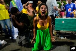 Supporters of Brazilian President Jair Bolsonaro react to results after polls closed in a presidential runoff election, in Rio de Janeiro, Oct. 30, 2022. Brazil's electoral authority announced that former President Luiz Inacio Lula da Silva had defeated Bolsonaro to become the country's next president.