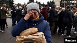 Nina Shevchenko, 65, reacts after she received humanitarian aid in the recently liberated town of Izium, in Kharkiv region, Ukraine, Sept. 27, 2022.