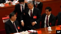 2022年10月22日，在北京人民大会堂举行的中共二十大闭幕式上，前中共总书记胡锦涛被警卫扶着离席。